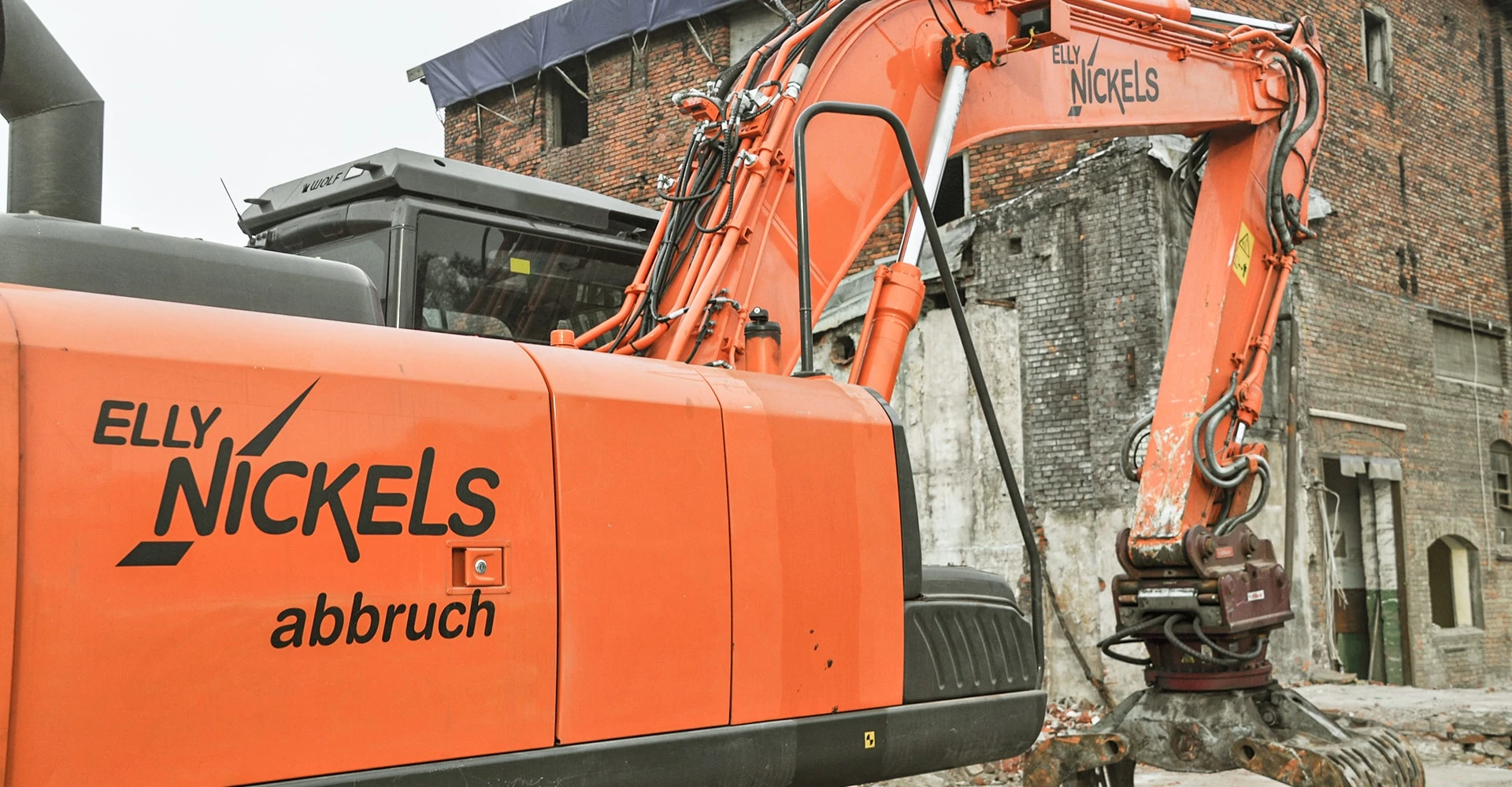 Ein orangeroter Bagger von Elly Nickels von der Seite